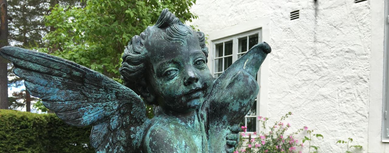 Staty av en kerub i trädgården på Hildasholm i Leksand. 