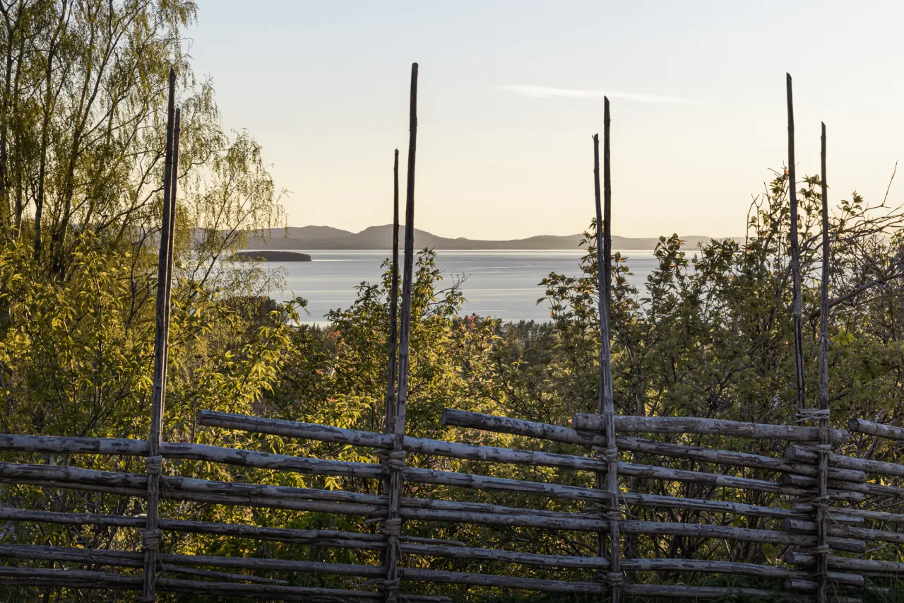 Vy över Siljan med gärdesgård i förgrunden.