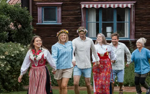 Ringdans på midsommar med traditionella dräkter från Dalarna och kransar i håret. 